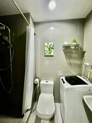 a bathroom with a white toilet and a sink at MyScape at Air Residences Makati in Manila