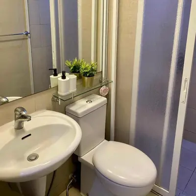 a bathroom with a white toilet and a sink at Casa Kalma - Beach View Staycation in Manila