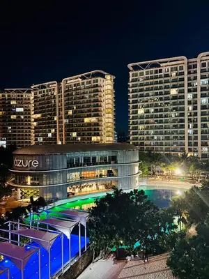 a building with a pool in front of two tall buildings at Casa Kalma - Beach View Staycation in Manila