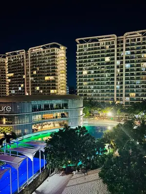 a large building with a pool in front of it at night at Casa Kalma - Beach View Staycation in Manila