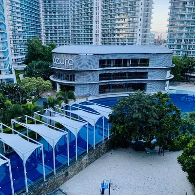 a large building with a swimming pool in front of it at Casa Kalma - Beach View Staycation in Manila