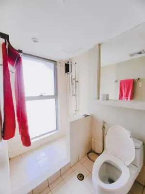 a bathroom with a toilet and a window at 2BR 90sqm Furnished Condo Shaw Blvd, Mandaluyong in Manila