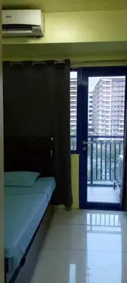 a bedroom with a bed and a window with a view at Ladybugs Condotel SR in Manila