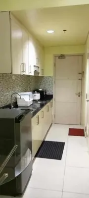 a kitchen with a sink and a door to a garage at Ladybugs Condotel SR in Manila
