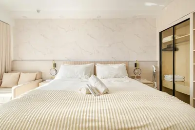 a bedroom with a large bed with white sheets at Hotel Like Staycation Near Airport and MOA Porongs Oasis in Manila