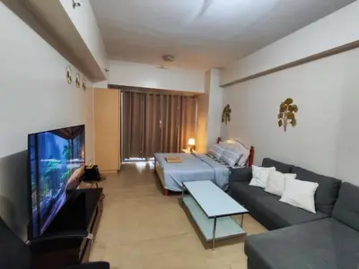a living room with a couch and a flat screen tv at L&D Condominium in Manila