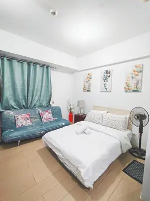 a bedroom with a bed and a couch in it at Rose150newportpasay in Manila