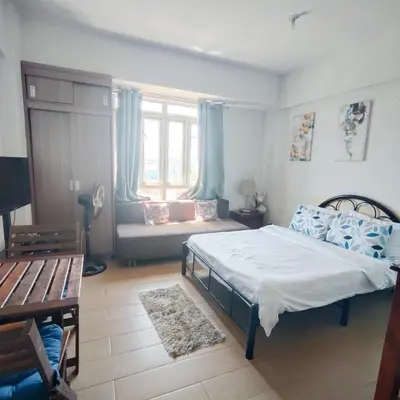 a bedroom with a bed and a couch in it at Rose150newportpasay in Manila