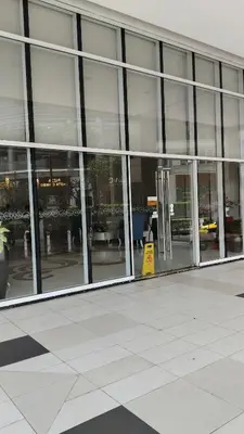 a large glass building with a yellow sign in front of it at Rose150newportpasay in Manila