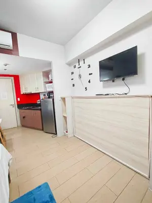 a kitchen with a large garage with a flat screen tv on the wall at Rose150newportcondopasay in Manila