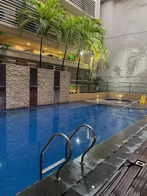 a swimming pool with a bench in a building at Rose150newportcondopasay in Manila