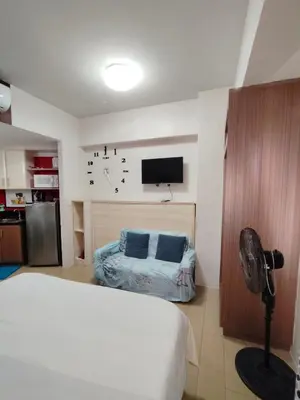 a bedroom with a bed and a flat screen tv at Rose150newportcondopasay in Manila