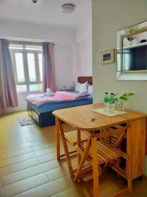 a room with a table and a bed and a bedroom at JennieRose150newportpasay in Manila