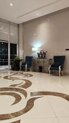 a lobby with two chairs and a rug on the floor at JennieRose150newportpasay in Manila