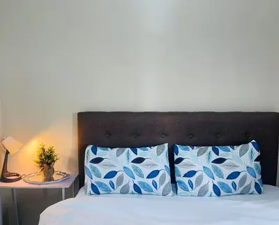a bedroom with a bed with blue and white pillows at JennieRosecondo150newportpasay in Manila