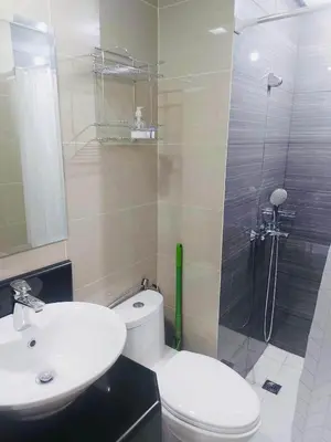 a bathroom with a toilet and a sink and a shower at JennieRosecondo150newportpasay in Manila