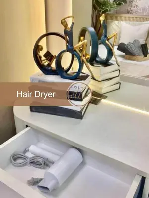 a shelf with three pairs of scissors and books at Modern Unit at Shore 2 Mall of Asia by Elle Suite in Manila