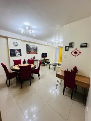 a living room with a dining room table and chairs at Unit 958 B Shell Residences 2br in Manila
