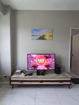 a large flat screen tv sitting on top of a table at Condo near Moa with Pool Access WS1205 in Manila