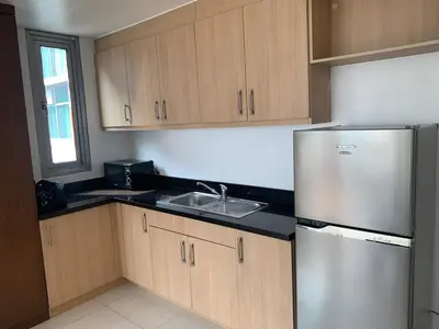 a kitchen with a stainless steel refrigerator and a sink at Avant at the Fort 360 City Center views in BGC Taguig w Pool Access in Manila