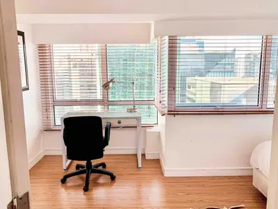 a bedroom with a desk and a chair in front of a window at 2BR Condo w Pool Loft at Fort Victoria BGC Taguig in Manila