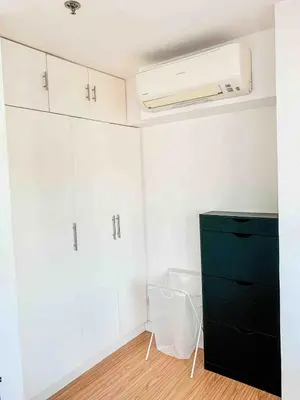 a room with a black cabinet and a white wall at 2BR Condo w Pool Loft at Fort Victoria BGC Taguig in Manila