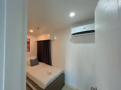 a small bedroom with a bed and a window at 2bedroom Loft Apartment within BGC in Manila