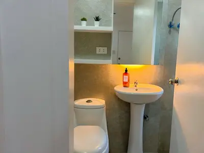 a bathroom with a toilet and a sink at 2bedroom Loft Apartment within BGC in Manila