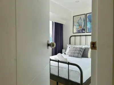 a bedroom with a bed with white sheets and pillows at 2bedroom Loft Apartment within BGC in Manila