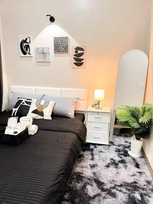 a bedroom with a bed and a desk and a plant at Nap & Go Staycation in Manila
