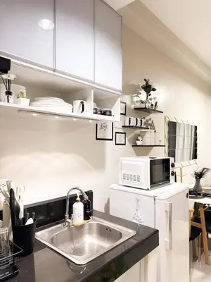 a kitchen with a sink and a microwave at Nap & Go Staycation in Manila