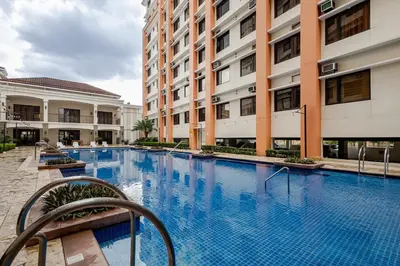 a large swimming pool in front of buildings at Self-Checkin - Piekny Dom - A Beautiful Home in Manila