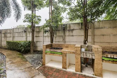 a stone bench in a garden with a fountain at Self-Checkin - Piekny Dom - A Beautiful Home in Manila