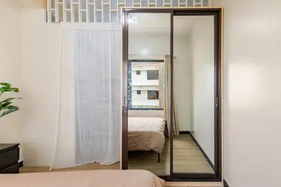 a mirror in a room with a bed and a bedroom at Self-Checkin - Piekny Dom - A Beautiful Home in Manila