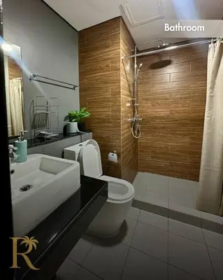 a bathroom with a toilet and a sink and a shower at The Radiance Manila Bay - DF Sy 19J in Manila