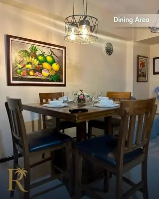 a dining room table with chairs and a painting of fruit at The Radiance Manila Bay - DF Sy 19J in Manila