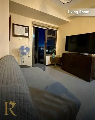 a bedroom with a living room with a bed and a flat screen tv at The Radiance Manila Bay - DF Sy 19J in Manila