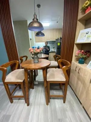 a kitchen with a wooden table and chairs with flowers on it at Propitious Place at Sta Mesa in Manila
