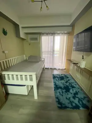 a bedroom with a bed and a large window at Propitious Place at Sta Mesa in Manila