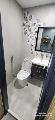 a bathroom with a toilet and a sink and a mirror at Propitious Place at Sta Mesa in Manila