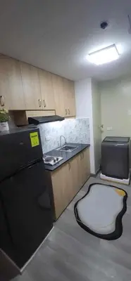 a kitchen with a black refrigerator and a sink at Propitious Place at Sta Mesa in Manila