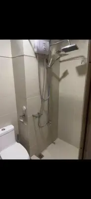 a bathroom with a shower and a toilet in it at S Residences MOA complex in Manila