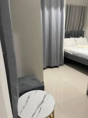 a small room with two beds and a stool at S Residences MOA complex in Manila