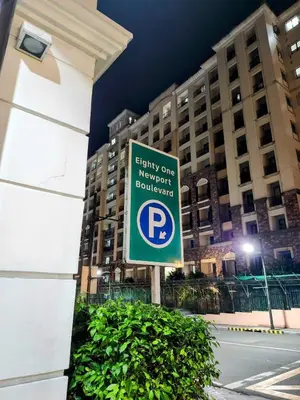 a parking sign in front of a building at Gallardo Condo Stays at Eighty One Newport Boulevard Newport City, Pasay City near NAIA Terminal 3 in Manila