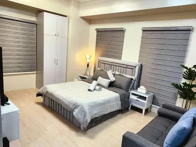 a bedroom with a bed and a couch at Gallardo Condo Stays at Eighty One Newport Boulevard Newport City, Pasay City near NAIA Terminal 3 in Manila