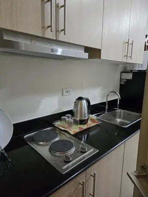 a kitchen with a stove top with a tea pot on it at Rhoydez Condotel Breeze Residence in Manila