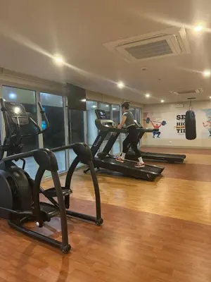 a woman running on a treadmill in a gym at Panoramic Landscape Seaview, 2BR, near Airport, 11m in Manila