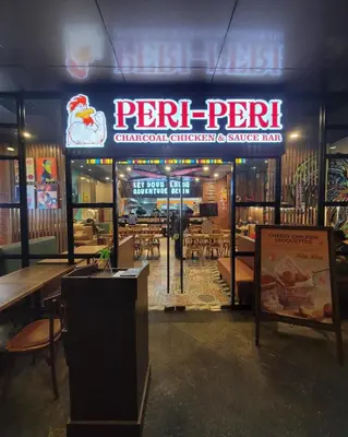 a restaurant with a sign and tables and chairs at Stylish 1br inside BGC at Uptown Parksuites - 24k in Manila
