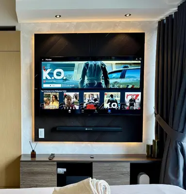 a flat screen tv on a wall in a room at Stylish 1br inside BGC at Uptown Parksuites - 24k in Manila