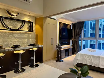 a hotel room with a bed and a television at Stylish 1br inside BGC at Uptown Parksuites - 24k in Manila